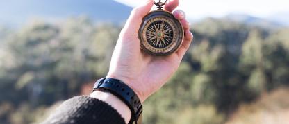 hand extended holding a compass outdoors